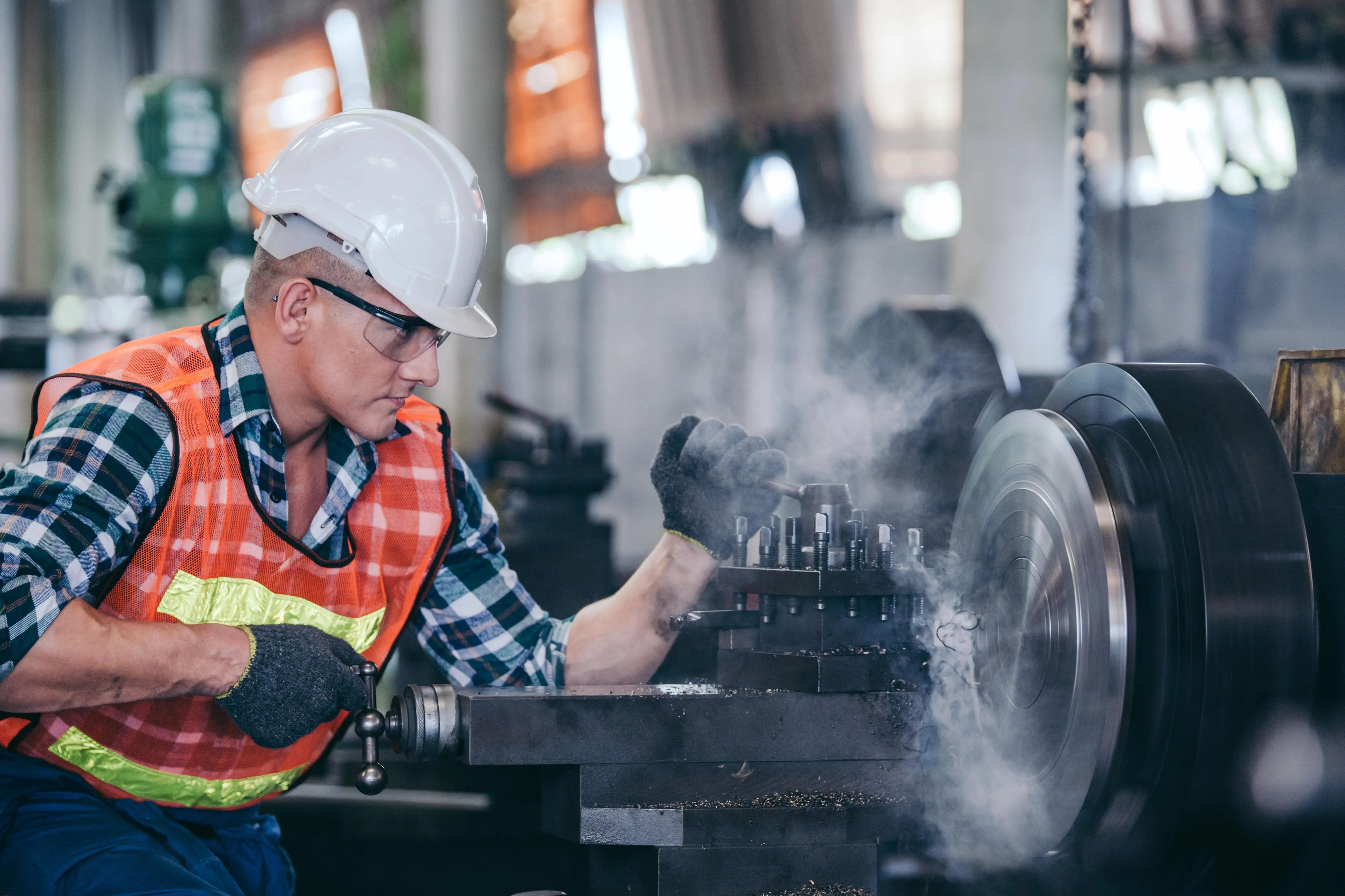 Skilled worker at a CNC lathe in production