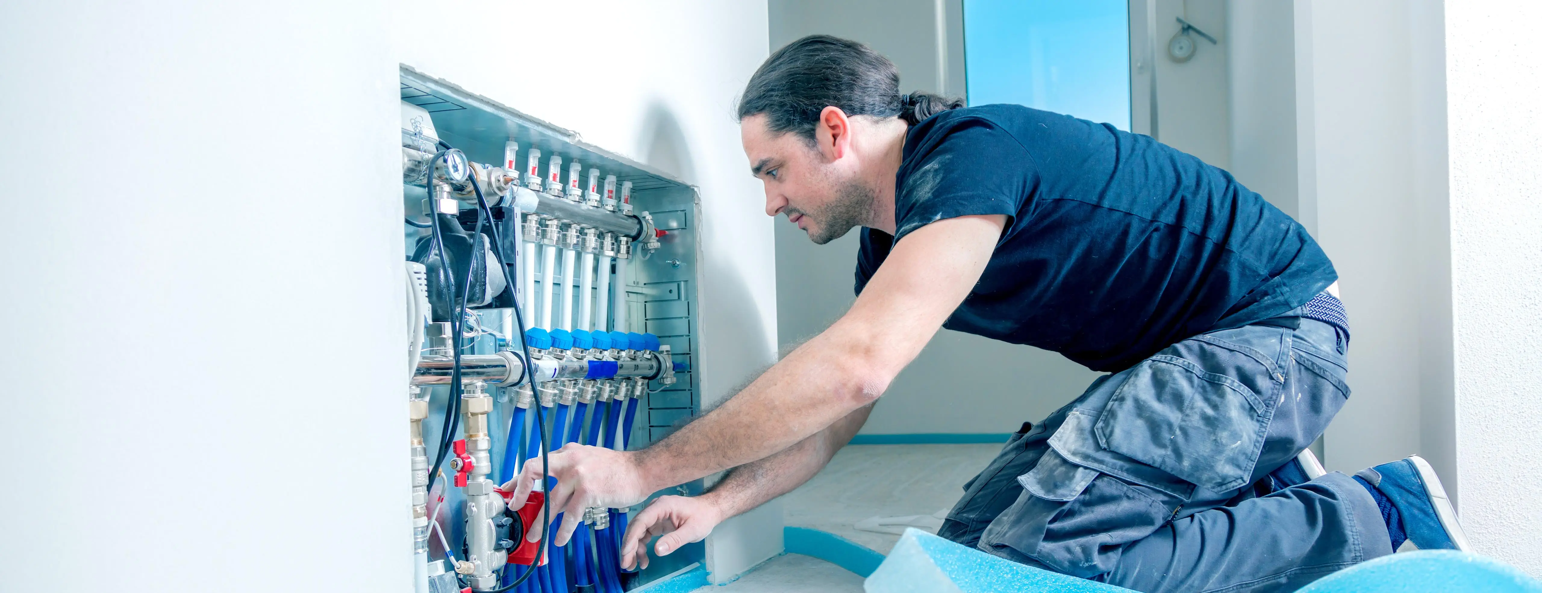 Installer fitting a heating manifold