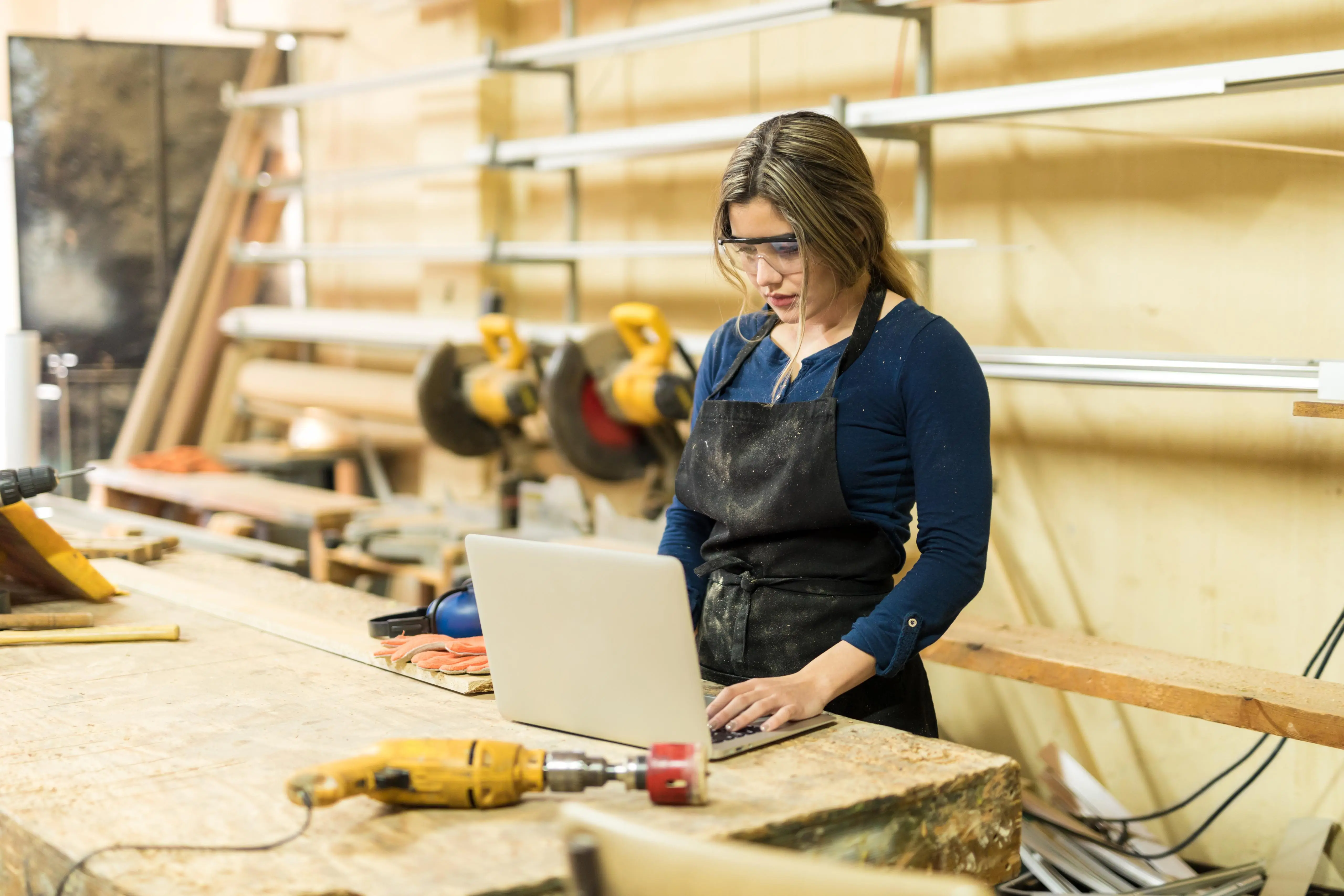 International professional with a laptop in a workshop